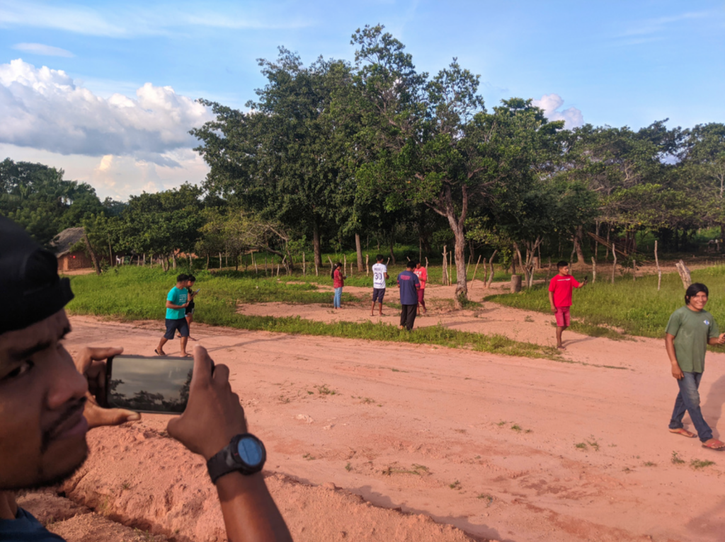 indigenous man takes a picture with his phone of the group